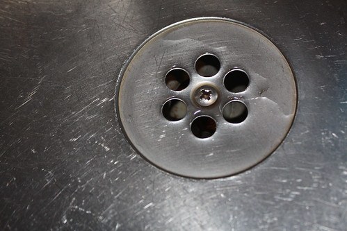An image of the bottom of a sink where the water flows through the drain.